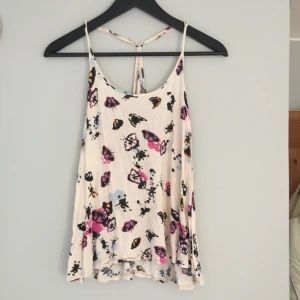  - Ett ljusrosa linne i storlek 34 med fjärilsmotiv. Mysig med naturligt fall. Använt men fint skick. 33kr +frakt