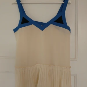  - Fint linne i chiffong med plisserade detaljer.