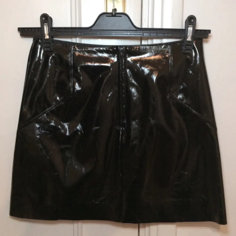 Kort, svart kjol i syntetlack från ASOS. I nyskick - använd endast ett fåtal gånger. Kan tvättas i tvättmaskin. . Kjolar.