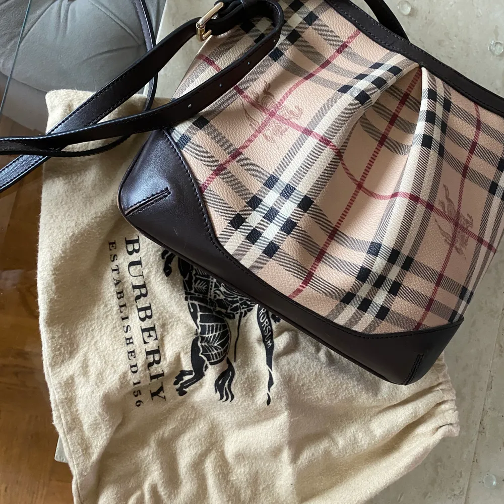 Säljer denna äkta burberry axelväska i vintage modell som knappast är använd och helt felfri. Köpt på NK för ungefär 5 år sedan så jag har inte kvittot kvar.. Väskor.