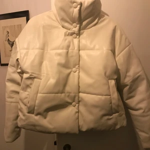 Nakd vit skinn-puffer - Vit dunjacka i pu med klädda knappar. Använd två gånger. Hakan har råkat färga lite bronzer på kragen men det går lätt att få bort med en wipe eller sminkborttagning. Har en likadan i svart och dom är väldigt varma och kragen är hög. Nypris 899:-