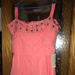  - Hel lång klänning aldrig använd inte testad äns  lappen hänger kvar på klänningen färg vattenmelon w22 är storleken och är ca 50 i svensk storlek men är väldigt liten i storleken så mer en 42-44 