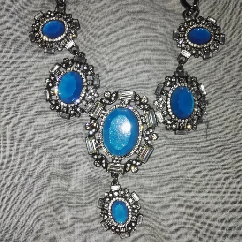 Halsband i kort modell med stora blå stenar . Accessoarer.