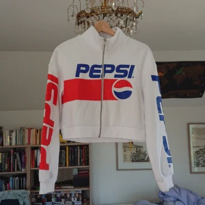  - Crop top från hm, tryckt med Pepsi fram, på ärmarna och loggan bak. Dragkedja hela vägen, hög krage. Aldrig använd utom när den provades i affären, og pris ca 300 kr.