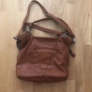  - Rymlig mjuk fejkskinnväska, böcker som är lite större än A4 block får plats. 2 innerfickor med blixtlås samt 2 fickor för mobil/plånbok finns i väskan. Avtagbara handtag.     Möts upp i T-Centralen/Skogås eller fraktar mot kostnad. 