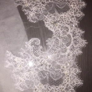  - Oanvänd spansk slöja i ovalform med extremt fin spetskant med fina stenar och paljetter på. Ca 3meter lång. Säljs för 1000kr.