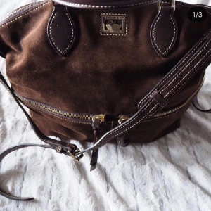  - Oanvänd, Superfin väska från Dooney & Burke.  Mocka & äkta läder. Aldrig använd. Bra storlek och massa mindre fack. Axelrem & handtag.