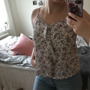  - Superfin blommig blus med volang i fram och tunna band! Använd 1 gång. Frakt tillkommer 🌸