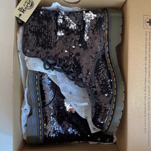 Dr. Martens stövlar med paljetter  - Ett par sjukt coola äkta dr. martens skor med paljetter på i strl 41. Oanvända (nyskick) och köpta för 1700kr i butik förra året men har då ej kommit till användning. De kommer i originalförpackning, meddela för fraktkostnad💘 Kan även mötas i Stockholm!✨