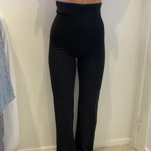 Högmidjade mjukisar/kostymbyxor  - Svarta (snyggare mjukisbyxor) med synliga linjer över rumpan & benen. Mjuka & sköna i materialet & bekväma. Väldigt hög midja då de går upp över naveln. Lite utsvängda längst ner. Sköna & bekväma på men ändå snygga. Köparen står för frakten 