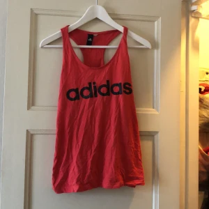 Adidas tränings linne  - Bra skick. Ljusröd med adidas tryck på bröst och rygg. 