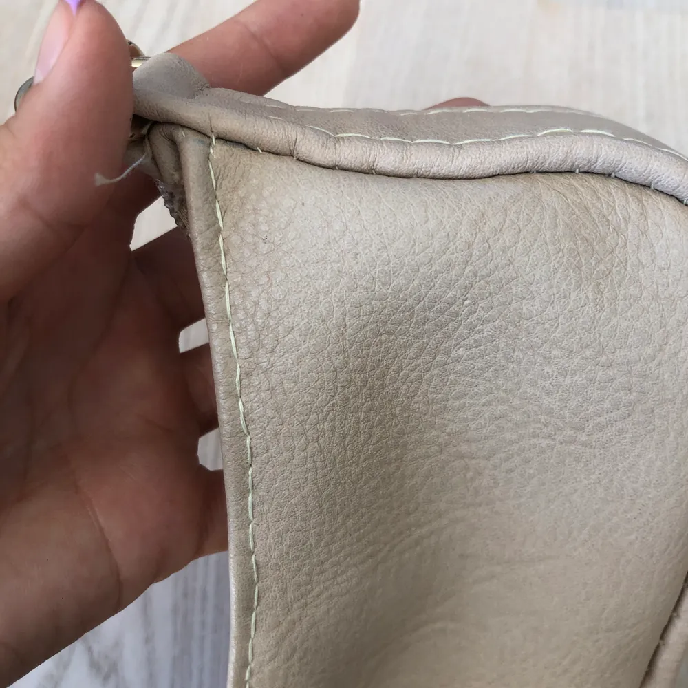 Liten beige shoulder bag i imiterat läder. Har sytt väskan själv från en större väska. Bandet, dragkedjan och metall detaljerna är direkt tagna från den tidigare väskan. Bandet är justerbart. Skriv för mer bilder. Priset är exklusive frakt. Väskor.