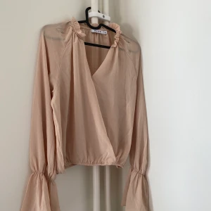 Söt blus - Söt blus från NA-KD. Armarna går ut i ärmslutet. Kan mältas upp i Halmstad annars står köparen för fraktkostnad.