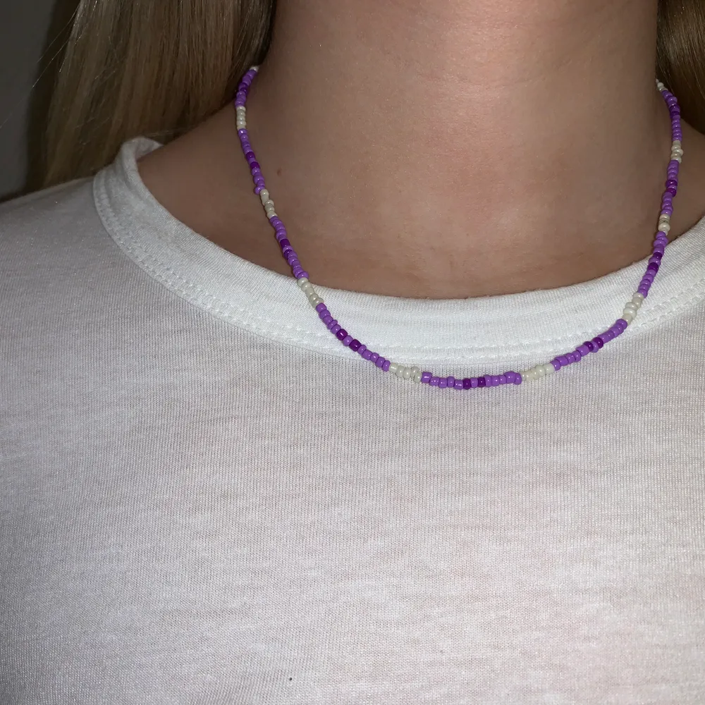Lila pärlhalsband med små pärlor💜🤍🤩💫🥺 halsbandet försluts med lås och tråden är elastisk . Accessoarer.