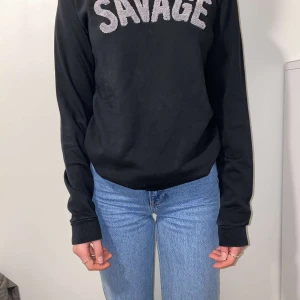 Svart sweatshirt med tryck - Svart sweatshirt med trycket "SAVAGE". Det står storlek 16 men passar xs/s.