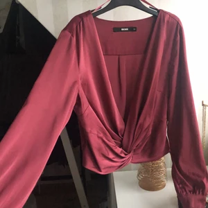 Siden blus i vinröd  - Siden blus i vinröd från Bikbok. Omlott med fin detalj framtill. Lite kortare modell som slutar ovanför höften. Stl Xs
