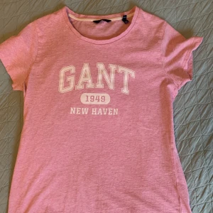 Rosa Gant T-shirt - Säljer en rosa t-shirt från Gant som är i mycket gott skick! Köptes förra sommaren för 349kr och säljs nu för 100kr inkl frakt. Priset kan diskuteras vid snabb affär. Betalning sker via Swish, varan kan fraktas runt hela landet. Fler bilder finns vid intresse.