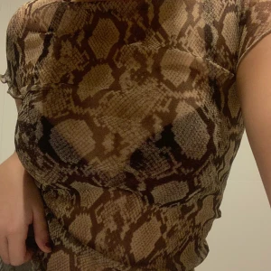 Glittrig meshtopp i snakeprint - Glittrig meshtopp i snakeprint från chiquelle i storlek XS, perfekt till fest!