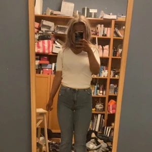 Vit blus från mango med gula detaljer - Jätte fin vit blus från Mango i storlek xs. Blusen har en v-ringning samt gula detaljer runt kragen och nedre kanten. Den är i fint skick.