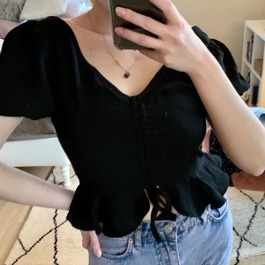 Topp - Säljer denna fina topp då den inte kommer till användning. Den har två band i ryggen som man antingen kan välja att klippa bort eller knyta i en rosett, jag har valt att ej använda dom, men dom sitter kvar! Fint skick, aldrig använd