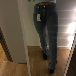 Zara- blåa bootcut jeans med slits - Blåa jeans från Zara i storlek 38. Aldrig använda pågrund av för långa. Även prislapp kvar. Ordinarie pris 359kr