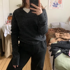 Grå v-ringad stickad tröja  - En lite tunnare stickad tröja. Köpt second hand men aldrig använd av mig, jättefint skick! 