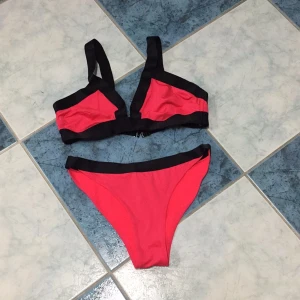  - Jättesnygg bikini i neonkorall. Breda reglerbara axelband samt knäppning bak. Oanvänd 
Överdel strl 42
Underdel strl 36

