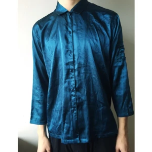  - Blåskimrig skjorta i sidenkänsla (polyester).