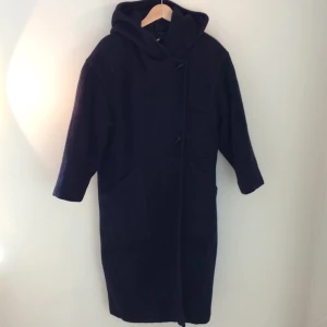  - Varm mörkblå kappa i ullblandning (35% ull) med stor luva