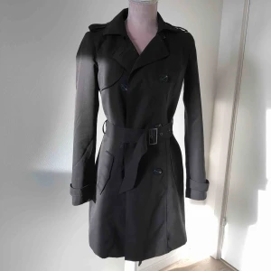  - Svart trenchcoat i storlek xs från Vila köpt på bubleroom. Nästan helt oanvänd och är i mycket bra skick.