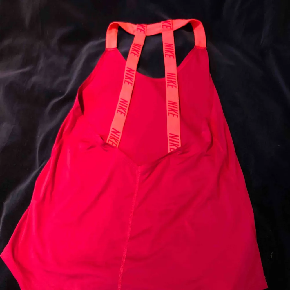 Ett lila/rosa tränings linne från Nike med en låg urringning vid ryggen. Den är i bra skick och är använd ett fåtal gånger:). Toppar.