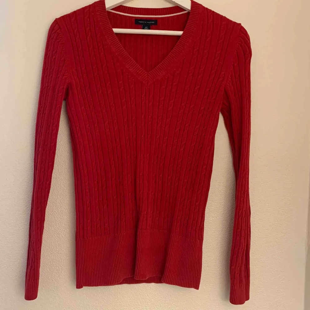 A nice red Tommy Hilfiger sweater that is in a very good condition and looks super nice with shirts underneath.. Tröjor & Koftor.