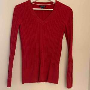 A nice red Tommy Hilfiger sweater that is in a very good condition and looks super nice with shirts underneath.