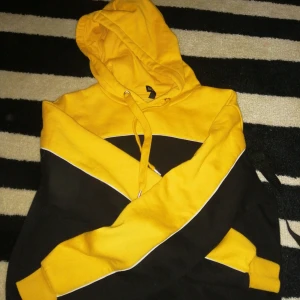  - En hoddie i gul, vit och svart. Dessutom är den magtröja.  Använt ca 4 gonger och tvättat ca 2,