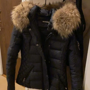 ROCKANDBLUE - ROCKANDBLUE är en mycket omtyckt dunjacka i kortare modell med smal passform som sitter perfekt. Luvan och fuskpälsen är avtagbar. Fickor med dragkedja i sidan. Justerbar i midjan med två spännen i ryggen. 