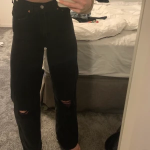 Levis Jeans - Svarta Levis jeans i bra skick. Hål på båda knäna och stora i benen. Modell ribcage wide leg. Jag är 174cm ungefär.
