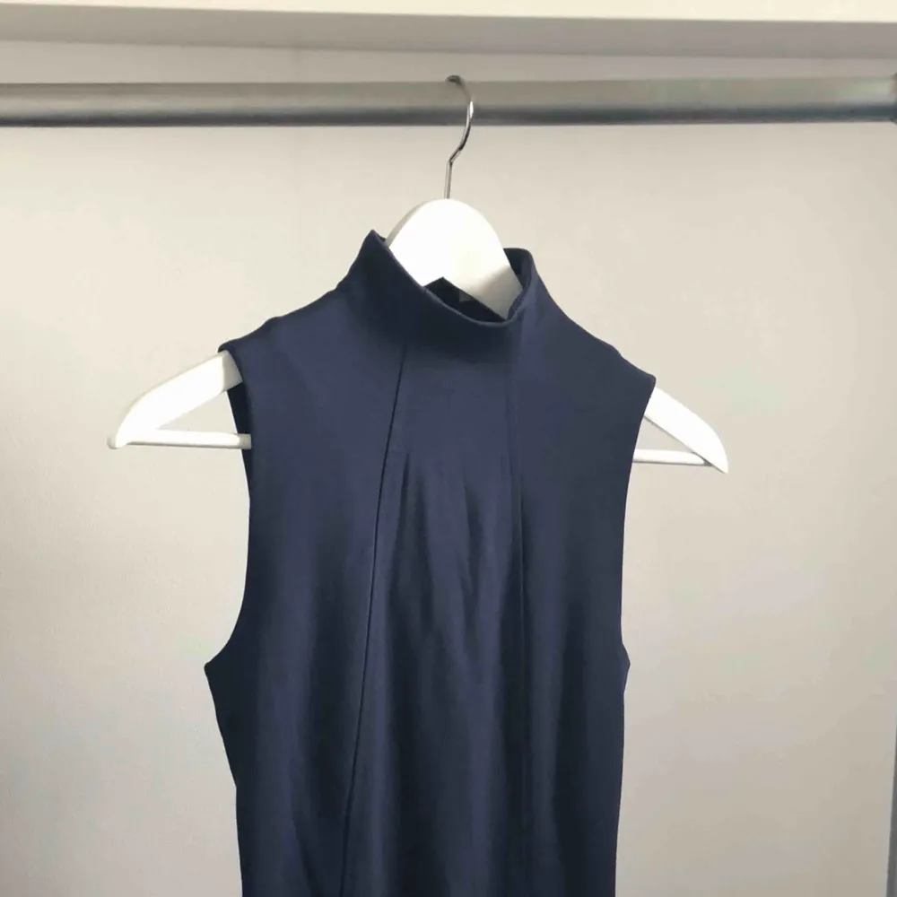 Mörkblå figursydd klänning från Calvin Klein med låg polokrage. Svart dragkedja i ryggen som går hela vägen ner, kan dra upp nedre dragkedjan för att kunna röra sig bättre. Använd 2 ggr passar xs-s. Klänningar.