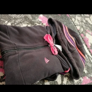  - Adidas tröja i fint skick (missvisande färg på bilden) storlek xs kameran missvisar färgen på tröjan, den är svart med rosa lila streck. (Pris kan diskuteras)