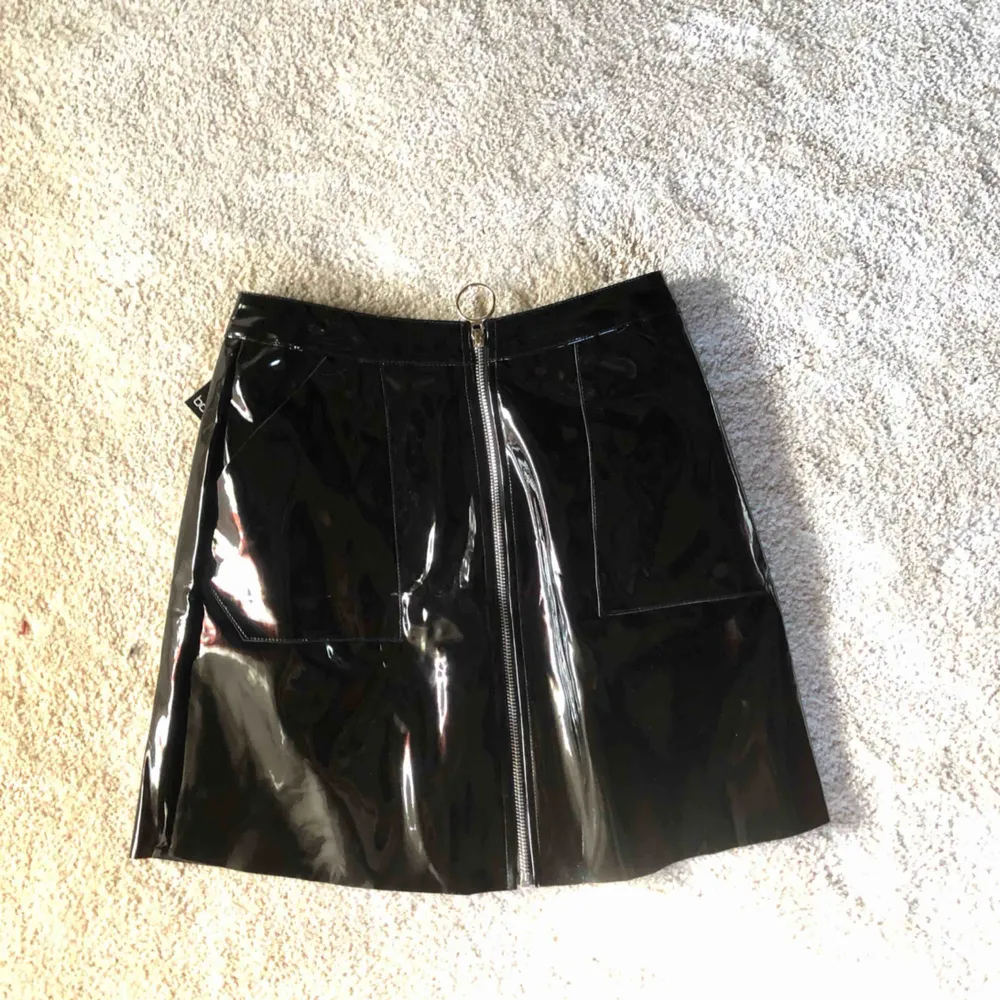Säljer denna svarta lack kjol från boohoo. Den är endast testad, lappen är kvar i. Jag är en storlek 34-36 o den sitter ganska pösigt på mig. Så som du  vill att den ska sitta tightare skulle jag rekommendera denna kjol för en 36/38! Frakt ca 30kr. . Kjolar.