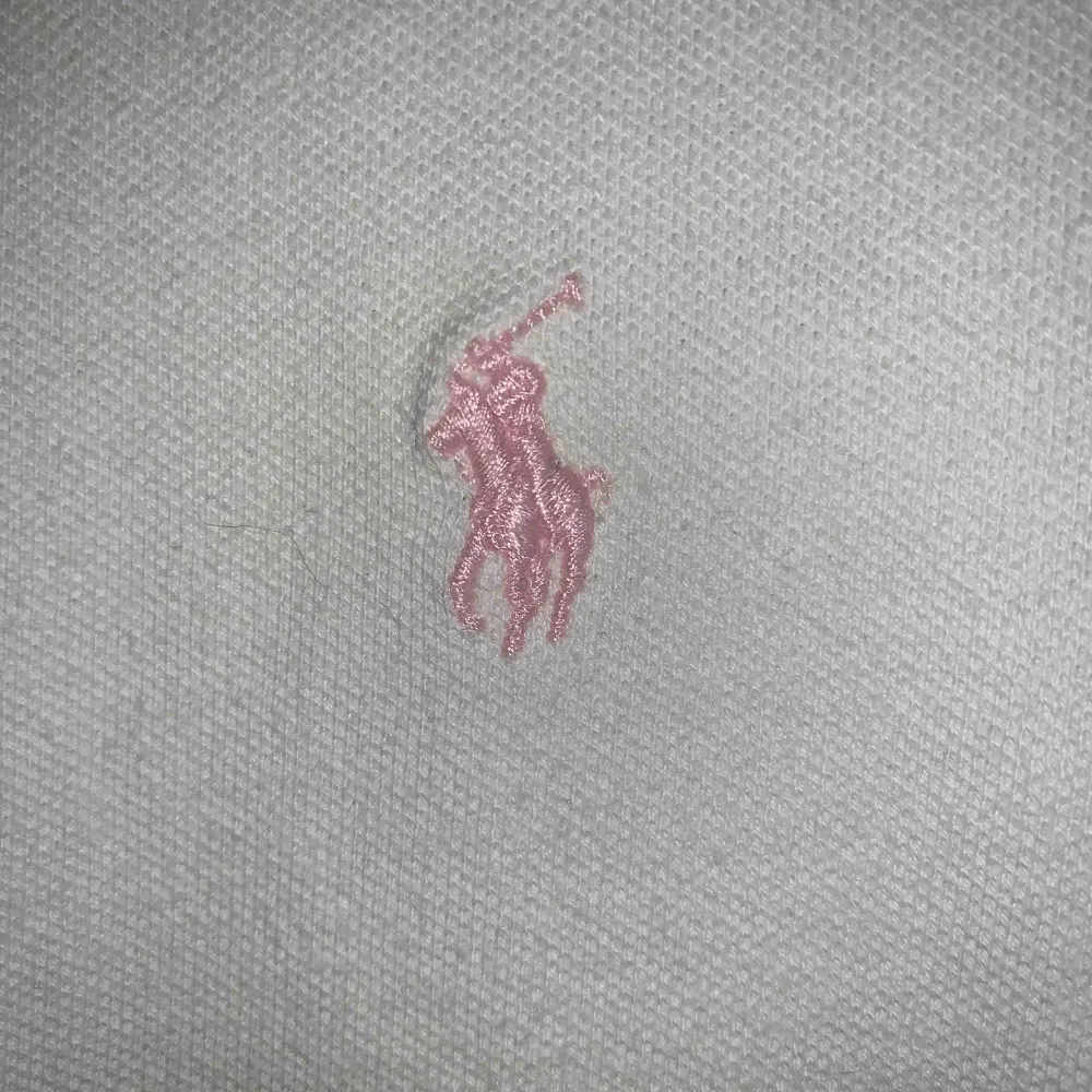 Vit piké med rosa detalj från Ralph Lauren, väl använd men bra skick. Köpt på NK i Stockholm, är en L i barnstorlek men passar som XS. T-shirts.
