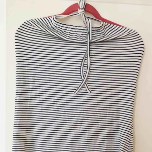  - Hellång klänning i vitt med mörkblåa ränder. Halterneck-ringning. Följsamt material, figursydd modell. Strl 40/42. Från märket ”Even&Odd”. Aldrig använd!