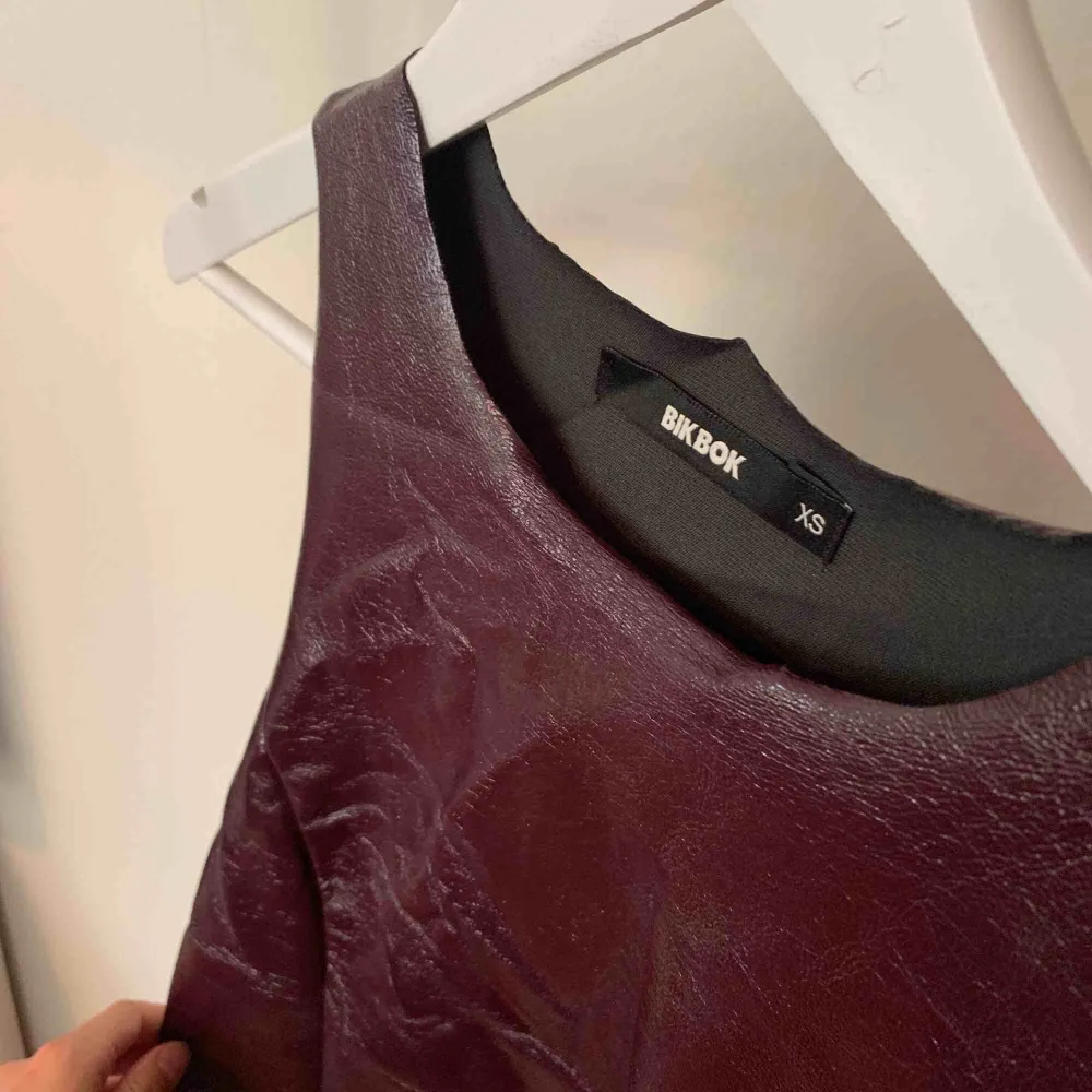 Sjukt cool klänning i fakeläder-material från BikBok!! Skulle se jättesnygg ut med en topp under☀️ Aldrig använd så i perfekt skick. Frakt 63 kr!. Klänningar.