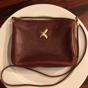 Vintage mindre handväska i brunt läder från Pourchet Paris (Made in France). Gulddetaljer och i fint skick!