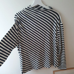 Marimekko asymmetrisk topp - En topp från Marimekko i mycket bra skick i supermjuk bomullstrikå. Sitter lagom på mej även fast jag är M och tröjan är L. Passar därför fler! Hurra!🧚‍♀️ Priset är exklusive frakt och köptes för 1000:-. 50 kr av detta köp kommer gå till välgörenhet!