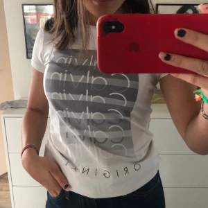 Calvin Klein t-shirt - Vit Calvin Klein t-shirt med ett grått tryck. Använd ett fåtal gånger och i väldigt bra skick. 