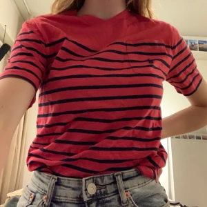 Ralph Lauren t shirt strl M - Ralph Lauren t shirt som är röd med mörk blåa ränder och en liten bröstficka med märket på. Nästan aldrig använd va 2-4 gånger. Därför väldigt bra skick. Frakt 20 kr men kan även överlämnas i Göteborg 