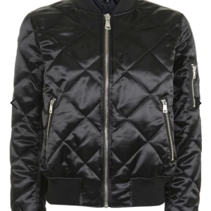  - Svart-glansig bomber jacka från Topshop i storlek 4, XS. Alla lappar sitter kvar så den är verkligen helt oanvänd. Originalpris 600kr. Bara att be om ni vill ha "riktiga" bilder :-)