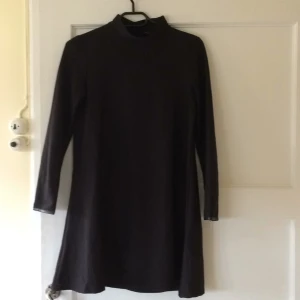  - Svart poloklänning i lite lätt glansigt material.  Ganska liten i storleken.  Kan mötas upp i Uppsala, annars står köparen för frakten:)