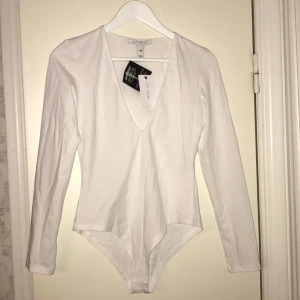  - Vit v-ringad body från Nelly. 50kr +frakt/eventuellt mötas upp i Gävle. Kontanter/swish går bra. 