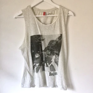  - Ljusgrå tank med Beatles-tryck fram och bak. Passar XS-M. Från H&M